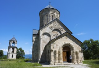 Romanesque church with bell tower in rural area under clear blue sky, Nikorzminda Cathedral,