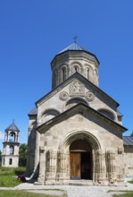 Historic stone church with bell tower against a clear sky, Nikorzminda Cathedral, Nikorzminda