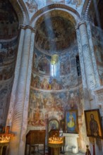 Church interior with frescoes and columns illuminated by a mystical ray of light, Nikorzminda