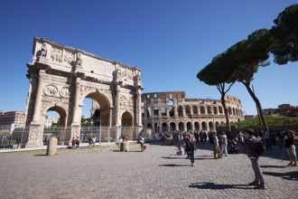 Arch of Constantine and Colosseum surrounded by tourists under blue sky, Rome, Lazio, Italy