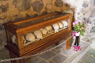 Bones in a wooden display case with flowers in a historical context, Chitakhevi Church of St.