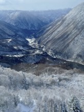 Snowy mountains and a valley with a river. The cold winter sky creates a calm atmosphere, winter,