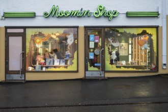 Illuminated shop window, shop in the city center selling merchandise and products related to the