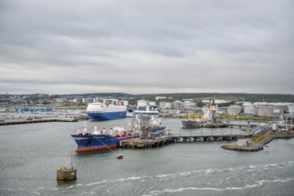 Industrial port with tanks and ships on calm water under a grey sky, Gothenburg, Västra Götalands