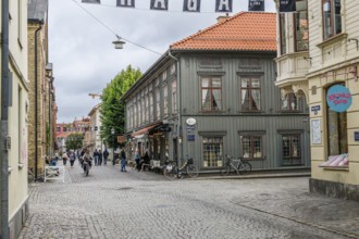 Charming old town with cobblestones and historic buildings, people walking on the street in