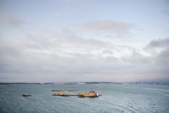 Wide sea with small rocky island under cloudy sky, Gothenburg, Västra Götalands län, Sweden