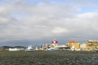 View of Gothenburg harbour with boats and municipal buildings under cloudy sky, Gothenburg, Västra