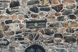 Detail of an old stone wall in Gothenburg's Skansen Kronan fortress with historic signs, rustic