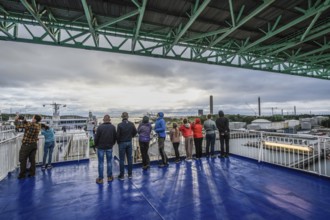 Group of people on a ship deck looking at the harbor crossing under the Älvsborgsbron suspension