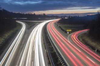 Evening long exposure of a motorway with light trails and cloudy sky in the background, near