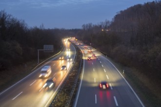 Long-exposure view of a busy highway at night, stars and lights in front of an evening sky, near