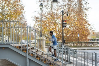 Man actively training by running up a metal staircase in a parisian urban setting, performing