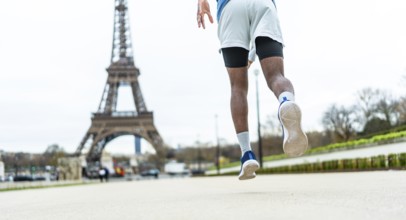 Man running on city street, elevating through a jump or stride, showcasing athleticism and an