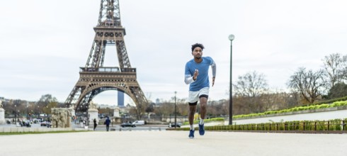 Young athletic man jogging through paris streets, focused on training and enjoying an outdoor