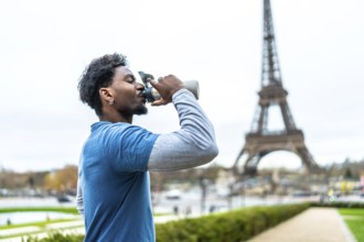 Black man staying hydrated. Drinking water from a reusable bottle after a workout with the iconic