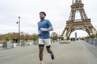 Young adult man with an arm prosthesis is running and smiling along the seine river with the iconic