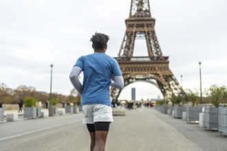 Person jogging on a parisian street with the iconic eiffel tower in the background, promoting urban