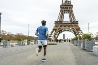 Young man running for fitness and healthy lifestyle in an urban park, exercising with the iconic