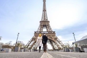 Young happy couple walking hand in hand during their city trip through paris, exploring the iconic