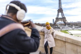 Couple traveling in paris. France. With a man taking a smartphone picture of his blonde girlfriend