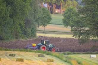 Tractor plows the field in an idyllic rural landscape, Osnabrücker Land, Lower Saxony, Germany