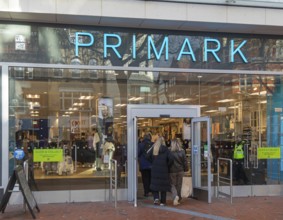 Shoppers entering through doorway entrance of Primark shop in town centre of Reading, Berkshire,