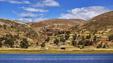 Wide landscape with hills, a lake and small villages, under a blue sky full of clouds, The