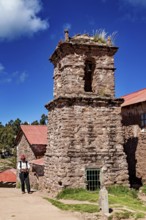 Old church tower with stone tower and a man in traditional clothing, The knitting men on the island