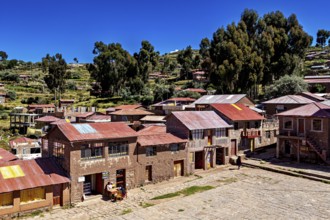 Historic buildings in an Andean village with a wide view of the surrounding area and a blue sky,