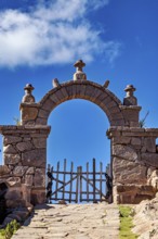 Stone gate under blue sky with some clouds, rustic appearance, stone gates on the island of Taquile
