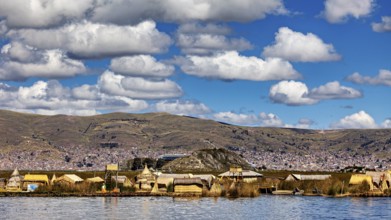 Village with traditional lakeside buildings surrounded by hills and clouds, The floating reed