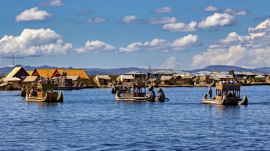 Several boats near a collection of reed huts on the lake, The floating reed islands of the Uros in