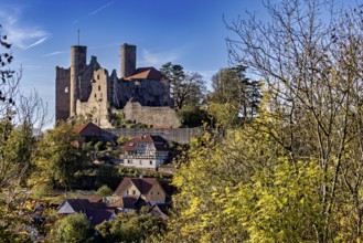 View of medieval castle above a village with autumn trees, Hanstein Castle near Bornhagen in the