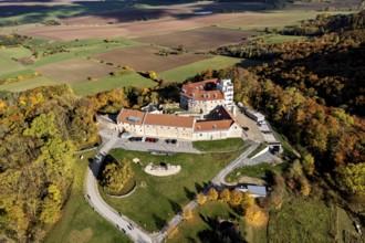 A castle on a hill with a bird's eye view of autumnal forests and fields, Schharfenstein Castle in