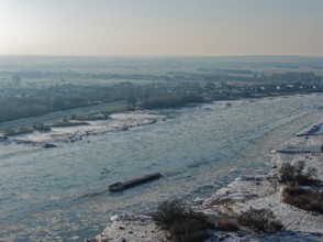 On a cold winter day, a barge sails downstream on the Elbe near Hamburg when there is slight ice.