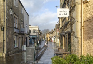 Wet pavements after rain in pedestrianised High Street are of town centre of Corsham Wiltshire,