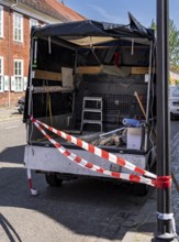 Red and white barrier tape in front of the back of a pickup truck, Potsdam, Brandenburg, Germany