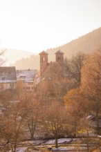 Idyllic snowy village with church towers and mountains in the background, Black Forest, Germany