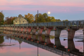 Illuminated Moulin Neuf water flow control dam and walkway over Des Mille-Iles river plus New Mill