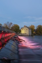 Illuminated Moulin Neuf water flow control dam and walkway over Des Mille-Iles river plus New Mill