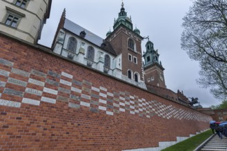 North façade of the cathedral on Wavelhügel, tourist group in the rain, Krakow, Poland