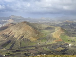 View of Montaña Tesa volcano from Montaña Blanca mountain with cloudy sky, Lanzarote, Canary