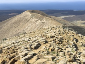 View from Caldera Blanca volcano against blue sky with white clouds, Mancha Blanca, Lanzarote,