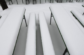 Winter in the English Garden, snow-covered beer garden tables and benches, Munich, Bavaria, Germany