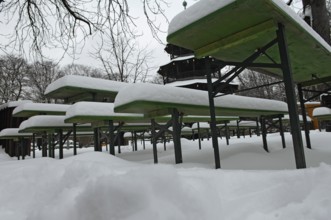 Winter in the English Garden, snow-covered beer garden tables and benches, Chinese Tower, Munich,