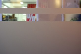 Symbolic picture of final sale: A percentage sign visible through the shop windows of a retail