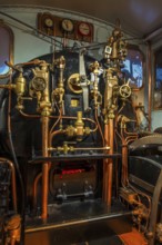 Pressure gauges and valves in steam engine cab, driver's compartment of steam locomotive at Train