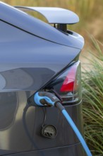 Close-up of electric vehicle / EV recharging at public charging station / loading point for