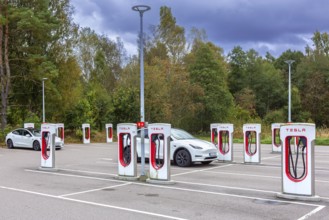 Parking area with public charging station / loading points from Tesla, network of rapid chargers