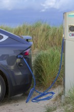 Electric vehicle / EV charging at public charging station / loading point for electric cars in the